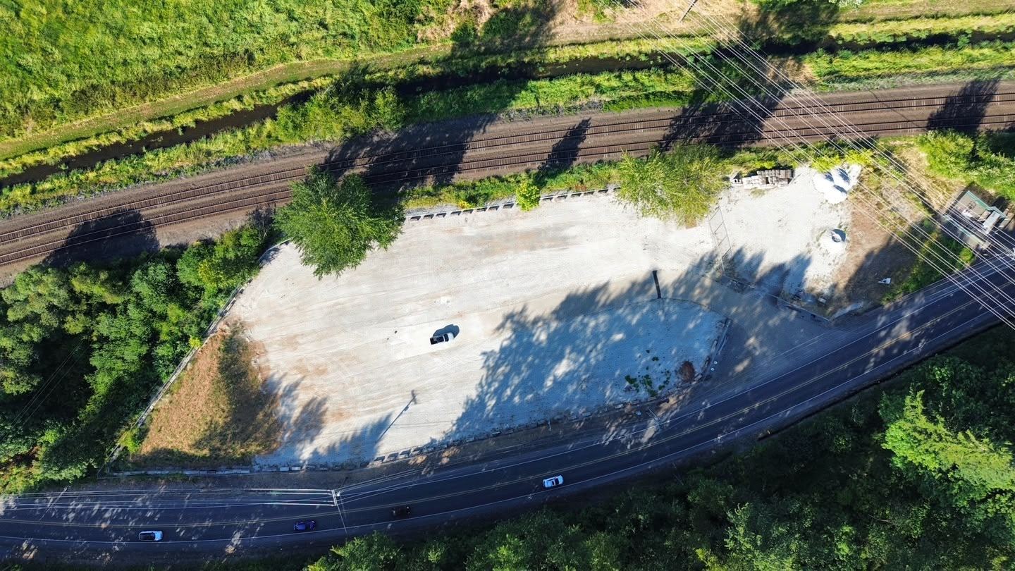 Drone photo of the gated Flame Truck Parking yard on Pioneer Way E in Tacoma, WA, between the rail line and the road